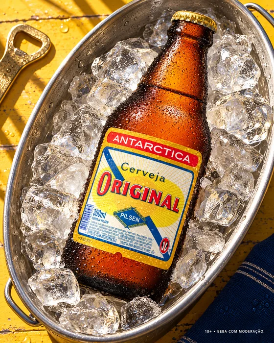 Botella de cerveza Original en un cubo con hielo.